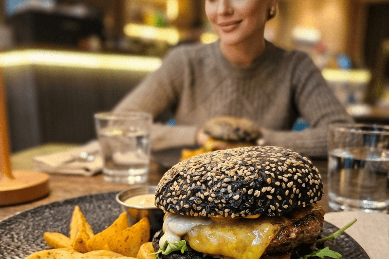 Hamburger gourmet con pane nero e patatine servito a Monselice